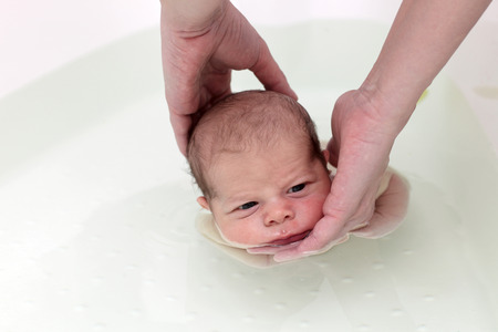 Mother teaches her son to swim in the bathの写真素材