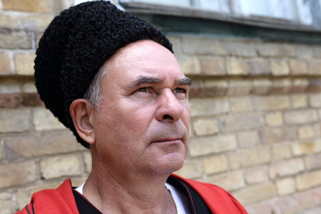 Face of a serious Kuban Cossack on the wall backgroundの写真素材