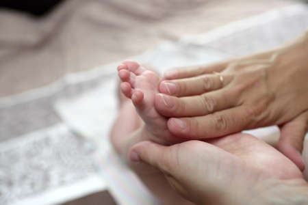 Person massaging the newborn foot at homeの写真素材