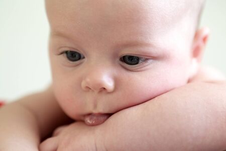 Portrait of a pensive baby boy at homeの写真素材