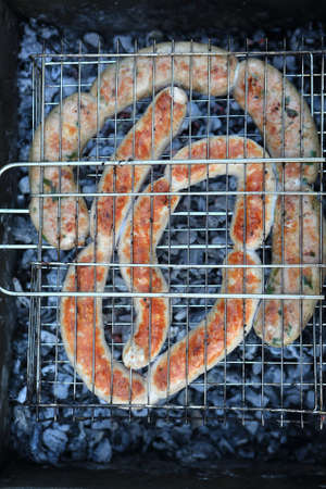 Grilling various sausages on the barbecue grill at picnicの写真素材