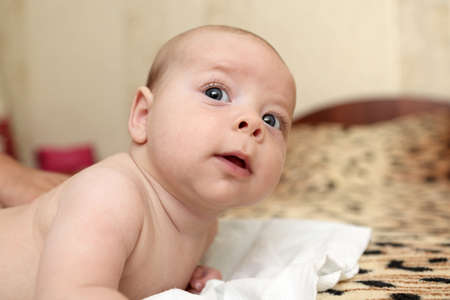Portrait of a baby boy on a bed at home