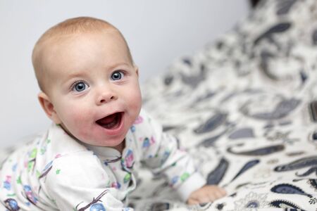 Prtrait of a smiling baby boy on a bed
