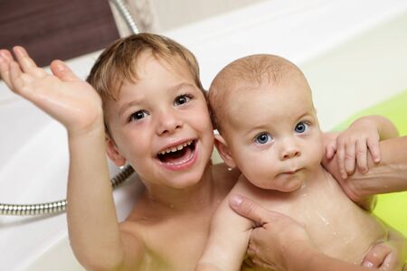 Two children take the salt bath at homeの写真素材