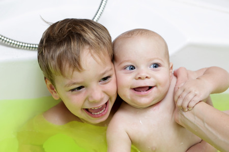 Two happy brothers take the salt bath at homeの写真素材