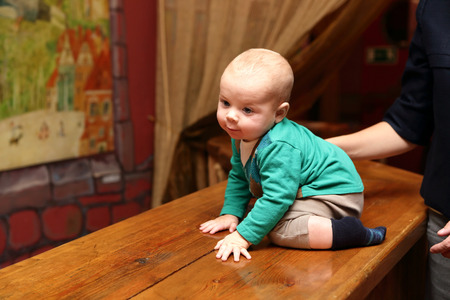 The curious baby boy sitting on the barの写真素材