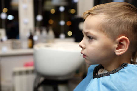 Portrait of thinking boy at the barbershopの写真素材