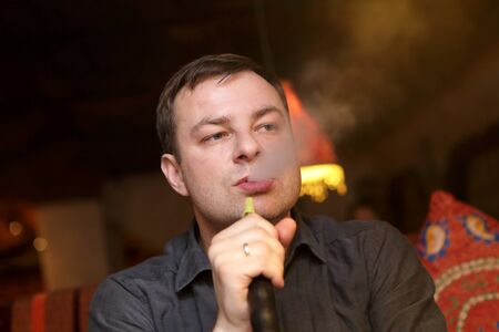 Man smoking nargile in the arabic cafe