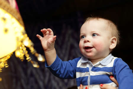 Baby boy looking at chandelier in the restaurant