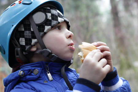 Boy eating cake in the spring park