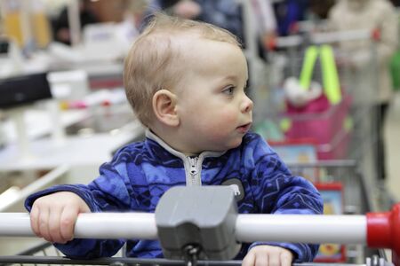Portrait of a toddler in shopping cartの写真素材
