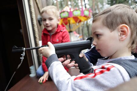 Kid shooting air pistol at the rifle rangeの写真素材