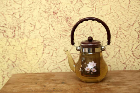 Teapot with herbal tea on a wooden tableの写真素材