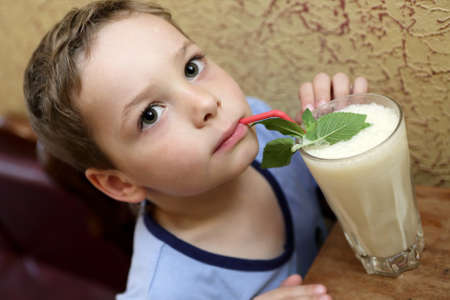 Child drinking milk shake in a cafeの写真素材
