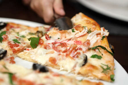 Person takes pizza in an italian cafe