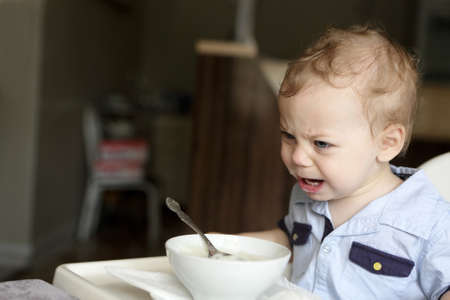 Toddler crying at the dinner table in cafeの写真素材