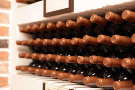 Bottles of wine on the shelves at wineryの写真素材