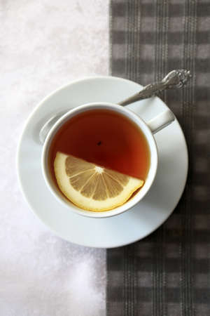 Cup of tea with lemon on a tableの写真素材