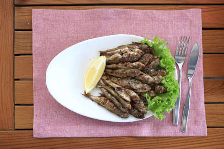 Crispy red mullet with lemon on plate in restaurantの写真素材