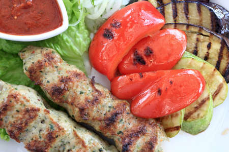 Kebab with vegetables on a plate in restaurantの写真素材