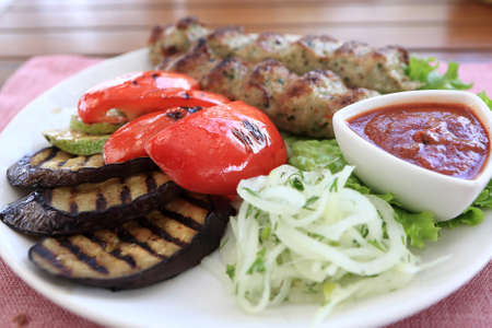 White plate with kebab on a table in restaurantの写真素材
