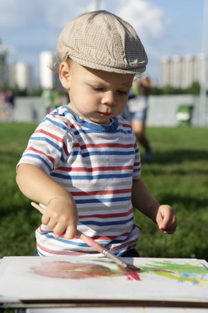Toddler drawing gouache in a summer parkの写真素材