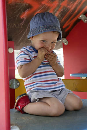 Toddler playing in wooden toy house at playground