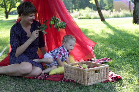 Family resting on rug in the parkの写真素材