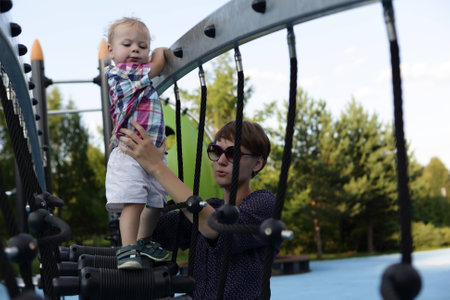 Mother with his son playing at outdoor playground