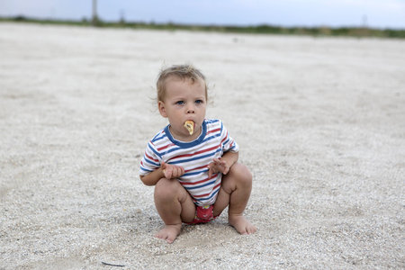 Boy eating pancake on a beach in summerの写真素材