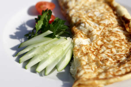 Omelet with cucumbers on a white plateの写真素材