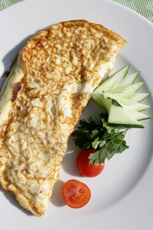 White plate with omelet on a table