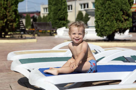 Boy resting on recliner at aquapark in summerの写真素材