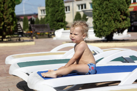 Child resting on recliner at aquapark in summerの写真素材