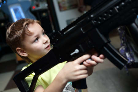 Boy playing with rifle in an amusement parkの写真素材
