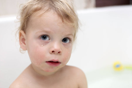 Portrait of a pensive child at bathroomの写真素材