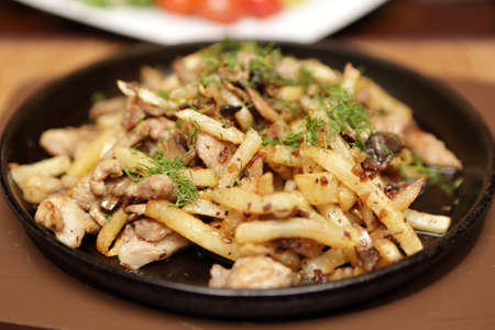 Pan with fried potatoes and meat in a pub