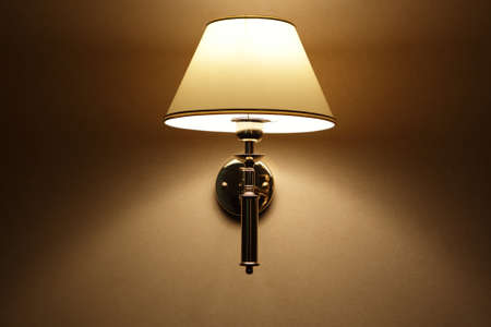 Glowing lamp on the wall at nightの写真素材