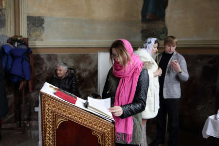 Teen reading bible in an orthodox church