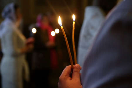 Person holding candles in an orthodox church