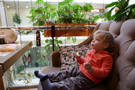 Portrait of a child with apple on sofaの写真素材