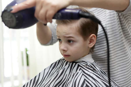 Portrait of serious boy in hairdresser salonの写真素材