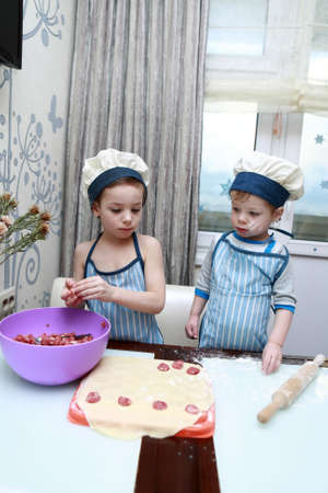 Brothers mold dumplings in kitchen at homeの写真素材