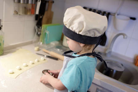 Child mold dumplings in kitchen at homeの写真素材