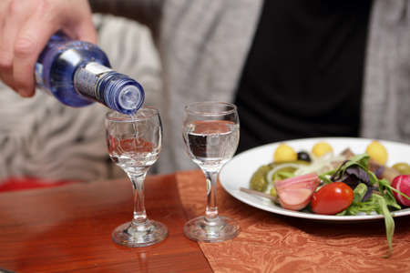 Person pouring vodka into glasses in a pubの写真素材