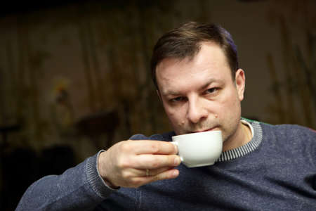 Man is drinking tea in a cafe