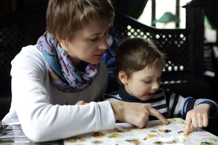 Mother and her son looking at menu in restaurant