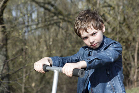 Child with kick scooter in the parkの写真素材