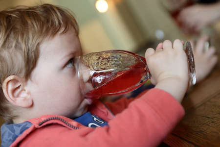 Serious child drinking juice in a cafe