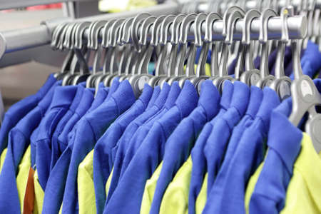 Knitted suits on hangers in a storeの写真素材